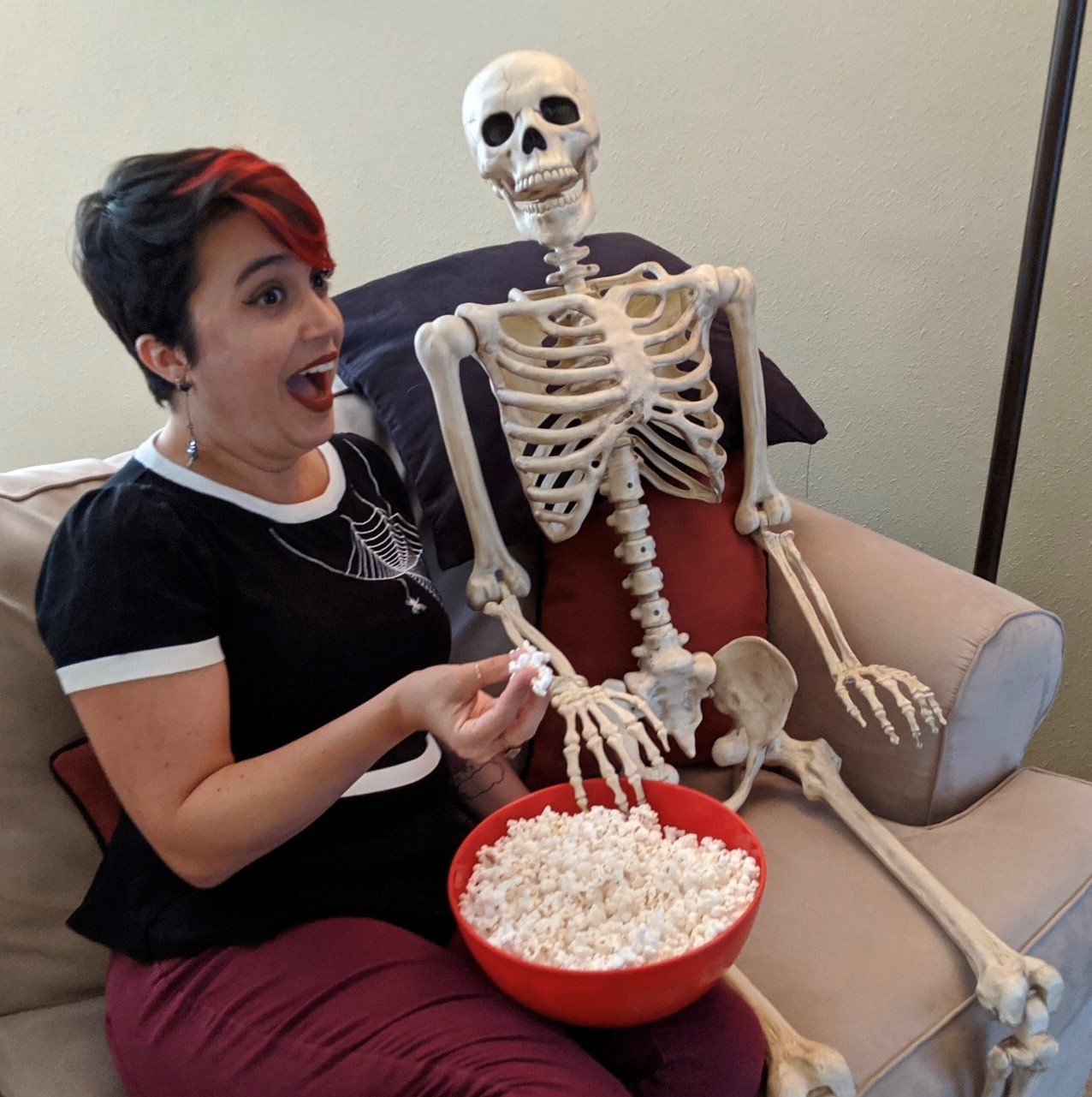 Member Moments logo with photo of MoPOP member Meghan Storms sitting on a couch eating popcorn next to a skeleton
