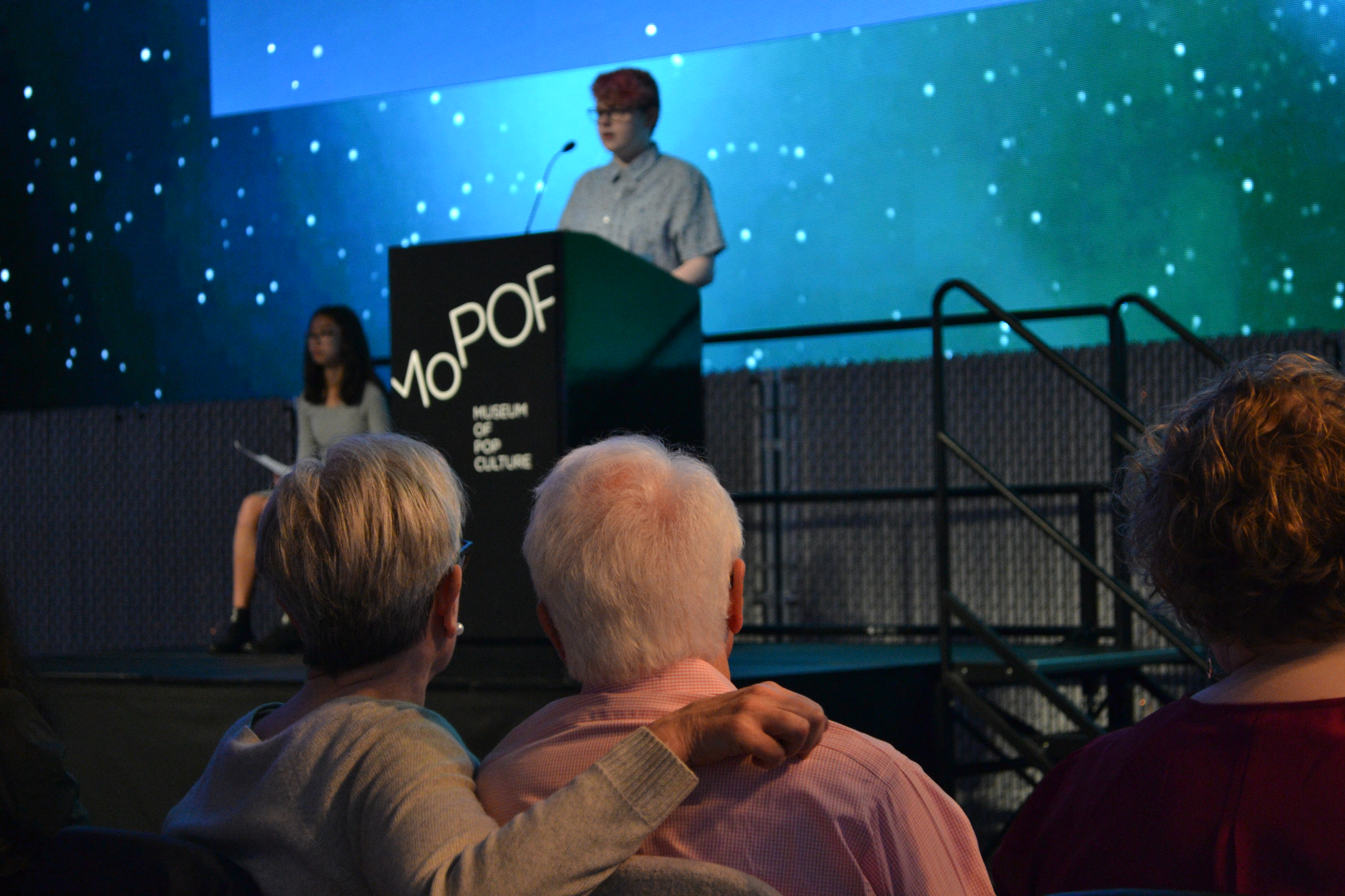 Visitors look on as 'Write Out of This World' contestant reads their story to audience in MoPOP Sky Church